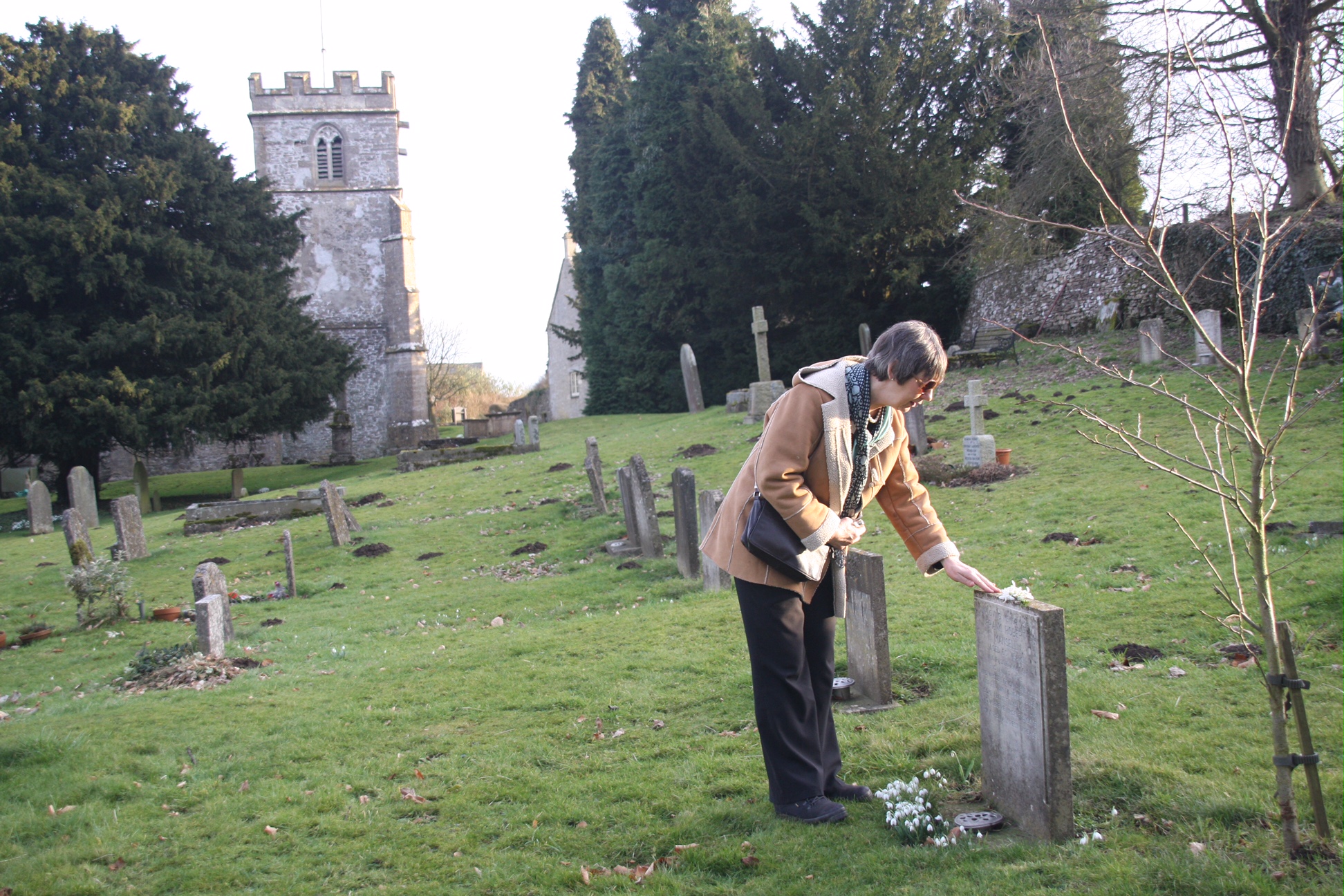 Frank Mansell - Diddley placing snowdrops on Frank's grave.