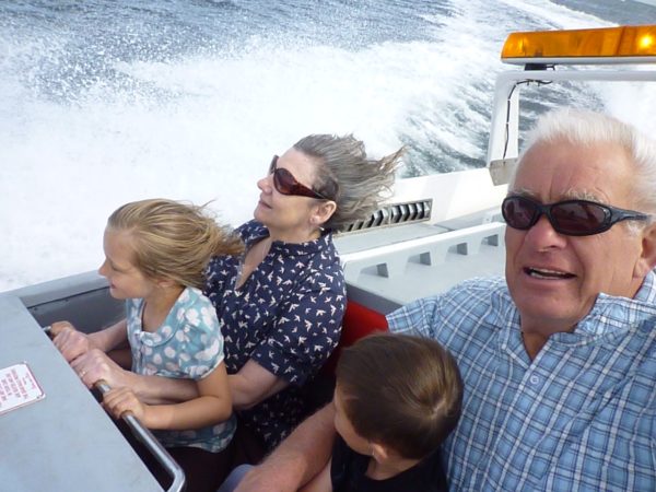 Bobby & Diddley on a speedboat ride. Each has a grandchild on their lap.