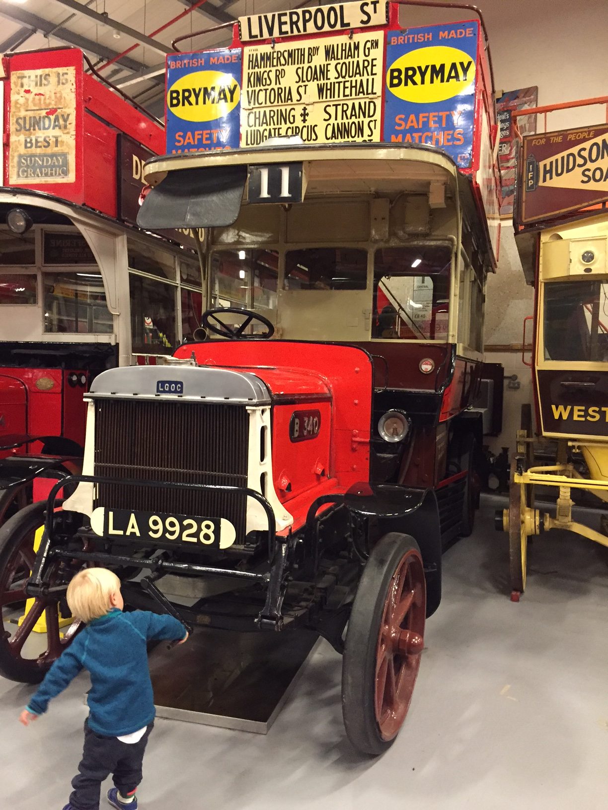 London Transport Museum: Well before Bobby, this. LA 9928. LGOC B-type bus B340. Solid tyres and a very young chap trying to turn the engine.