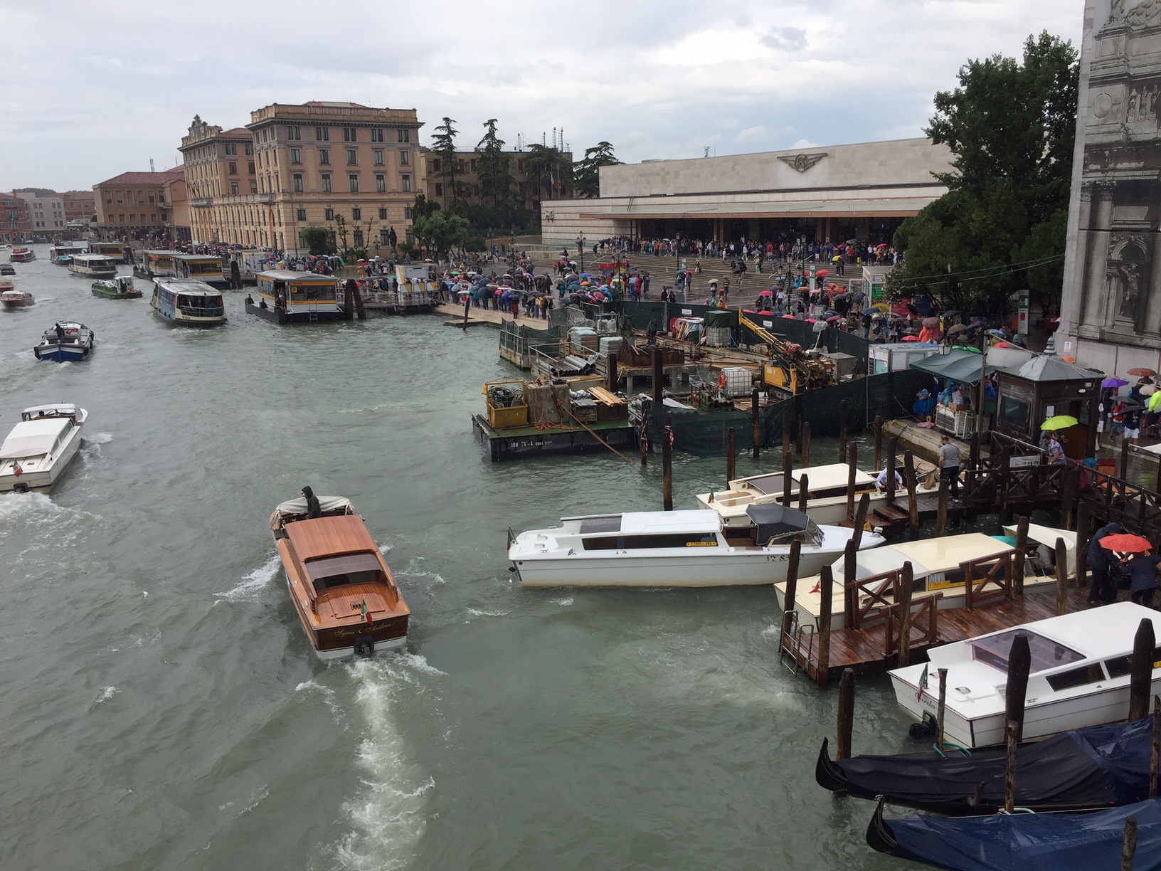 Venice Station: Venice Santa Lucia Station. Down the steps. Walk. Waterbus. Launch. Gondola. A man with a barrow.