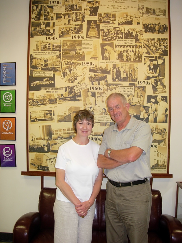 Shredded Wheaat: Diddley & Bobby in front of a poster depicting the factory over the decades.