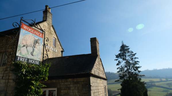 Cotswold Reverie: The Woolpack. Immortalised by Laurie Lee. Swift's Hill behind the pine tree.