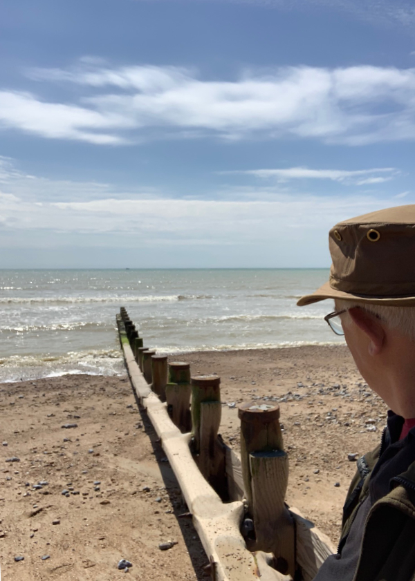 Bobby sat on a groyne on Ferring Beach looking out to the horizon over the sea.