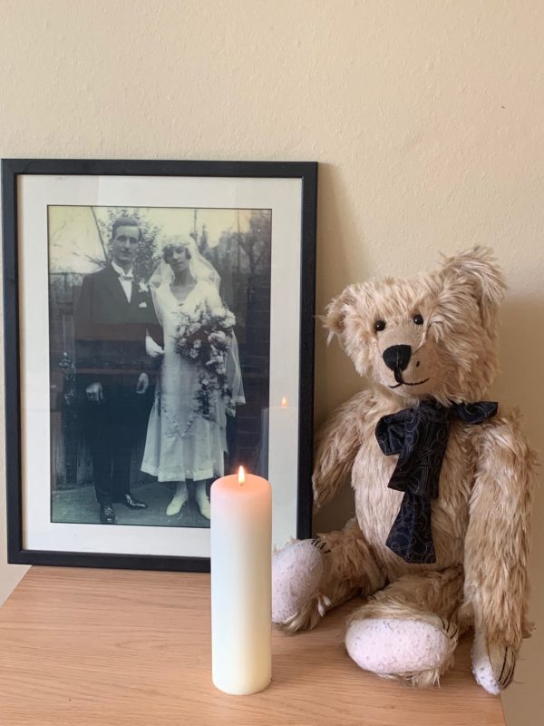 Bertie sat behind a large candle lit for Diddley. A framed picture of Bobby's parents on their wedding day in 1925 is next to Bertie.