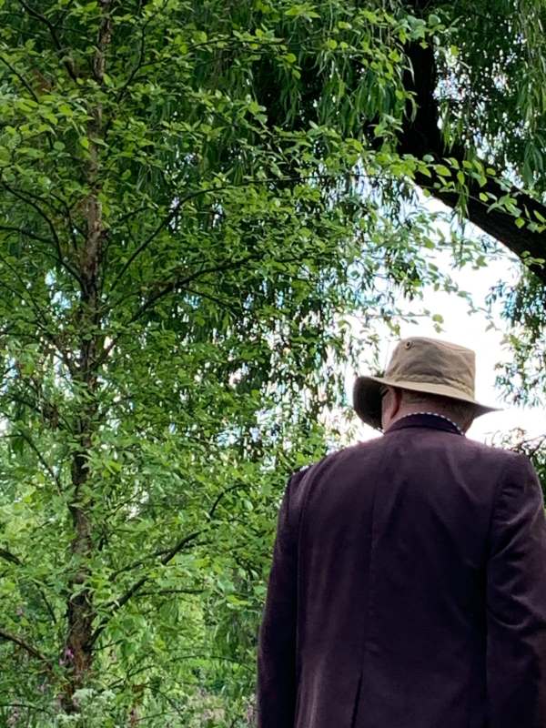 Photograph of a man walking past wearing a hat identical to Bobby's.