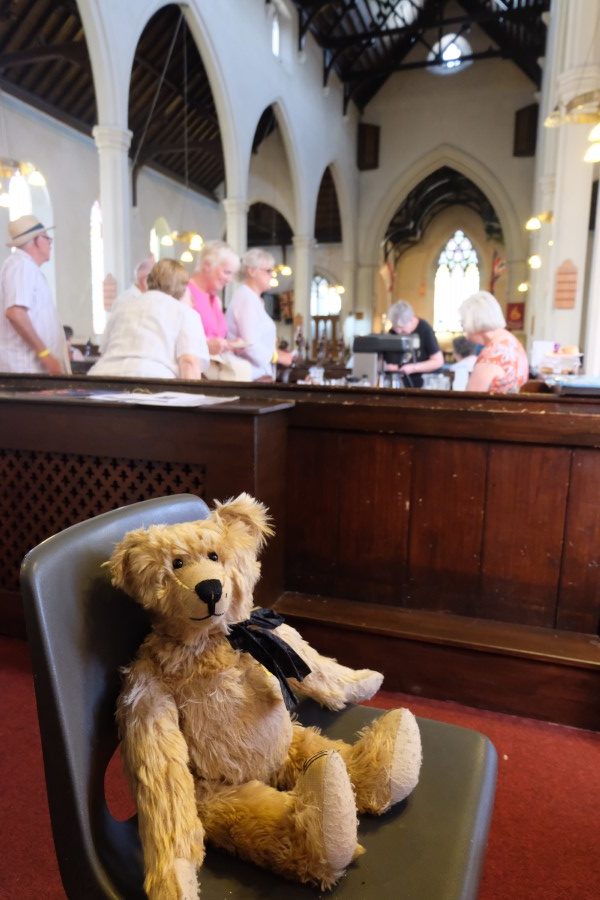 Bertie sat in a chair in the Nave, with tea and cake being served behind.