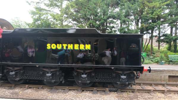 Photograph of the shiny black tender, with enthusiasts reflected in it!