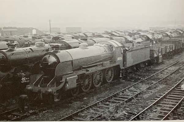 30506 amongst a line a locomotives, along with some trucks, awaiting scrap or salvage.