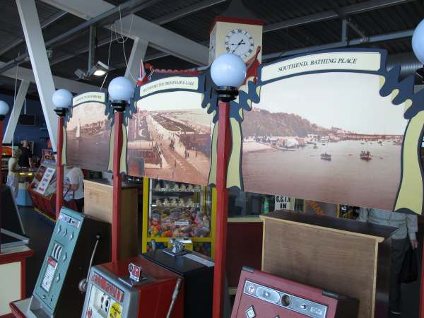 Historic images of coastal resorts above old slot machines on Southport Pier.