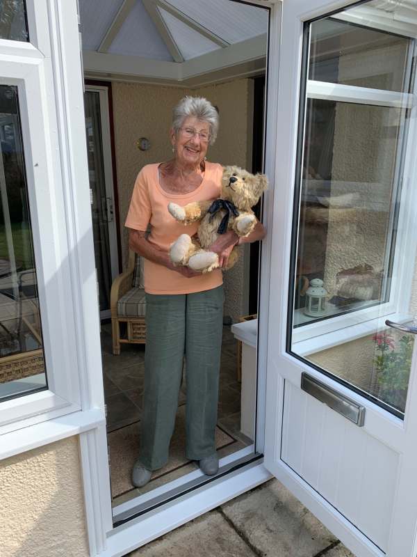 Bertie in Rosemary's arms in the doorway of her conservatory.