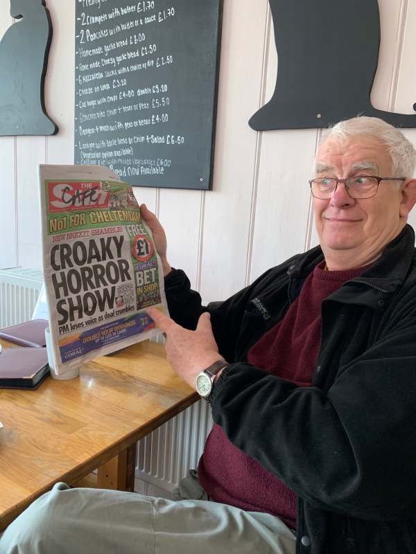 Bobby in the Black Caat café in Worthing, holding up a copy of the Sun newspaper.
