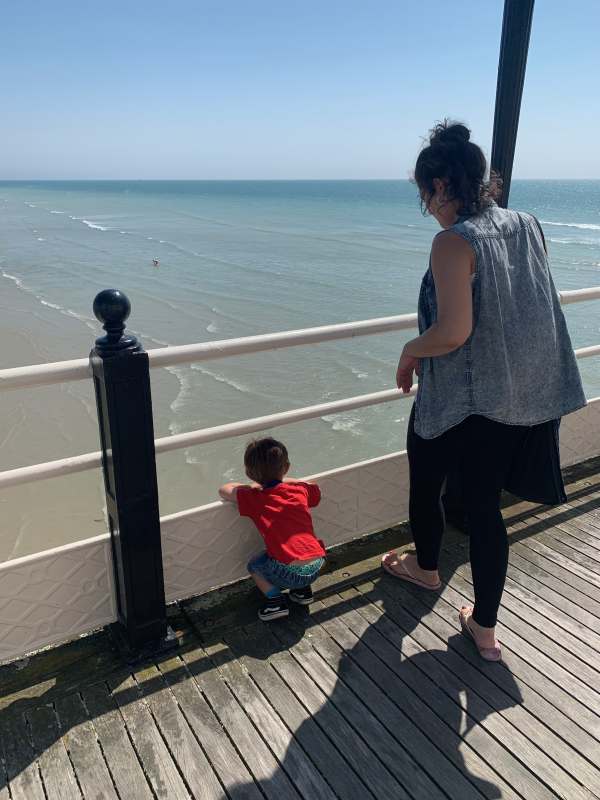 Jasmine, with Little Jay looking through the railings of Worthing Pier.