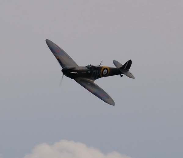 Spitfire flying in an almost cloudless sky.