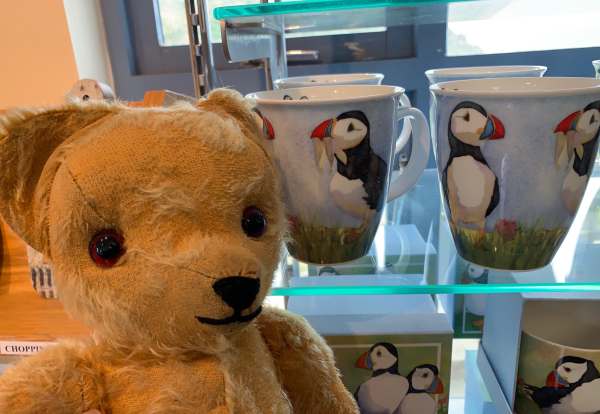 Eamonn in front of a display of mugs with puffins on them.