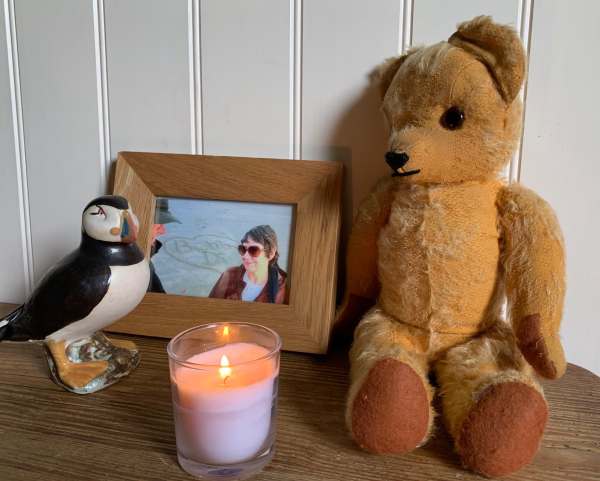 Eamonn in Laurel Cottage with a photo of Diddley, a Puffin - and a lit candle.