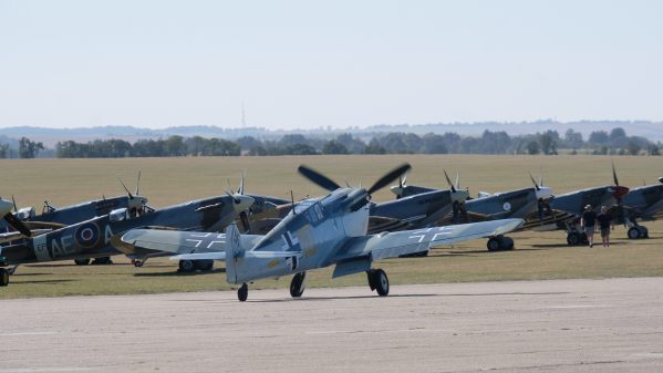Messerschmitt 109 taxiing along the runway in front of parked Spitfires at Duxford 2019.
