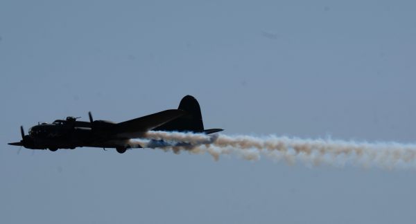Boeing B-17 Bomber Sally B playing to the crowd with smoke pouring out of the rear at the Airshow, Duxford 2019.