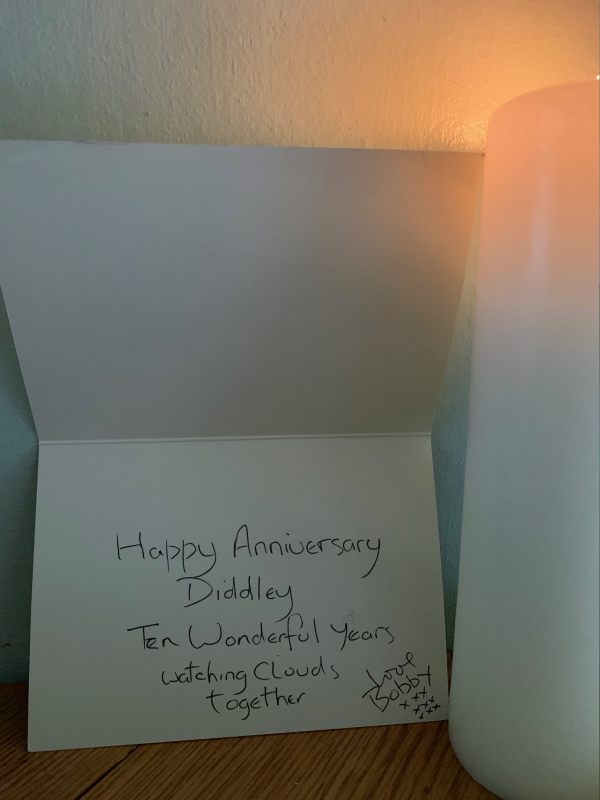The inside of the card, handwritten with: "Happy Anniversary, Diddley. Ten wonderful years watching clouds together. Love Bobby" with 9"x"'s in three rows.
