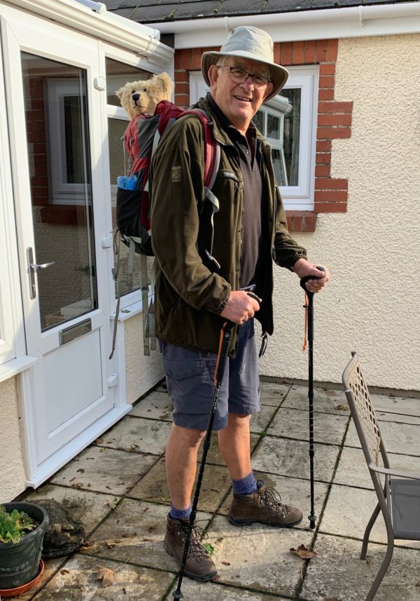 Bobby, with his rambling sticks, on the patio outside Rosemary's. Bertie is on Bobby's back in the rucksack. Both are looking right towards the camera.