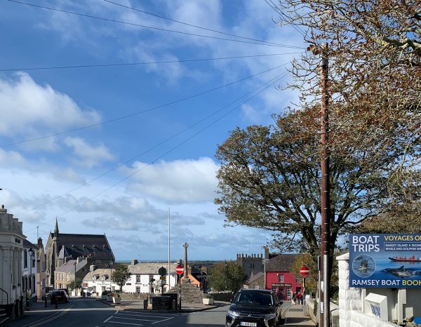 St David's. The Market Cross. The Bishops pub. The large Tavernacl Presbyterian church to the left. The tower of the cathedral right, off-centre. The sea beyond and, just visible, the Bishop and Clerks islands. Dangerous rocky places, with a protective lighthouse out of the picture at South Bishop.