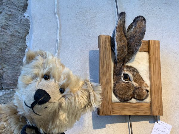 Bertie is posing in front of a 3D picture of a rabbit's head. The ears are sticking up over the top of the frame.