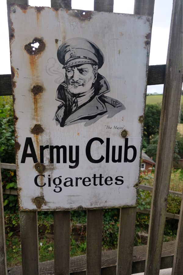 West Somerset Railway - Enamel Sign "Army Club Cigarettes" attached to a station fence.