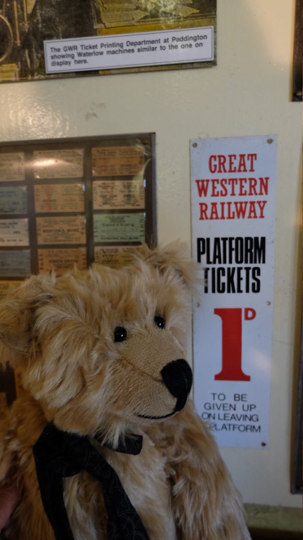 Somerset & Dorset Railway Trust: Bertie standing in front of an old Great Western Railway enamel sign advertising Platform Tickets at 1d - to be 'given up on leaving the platform'!