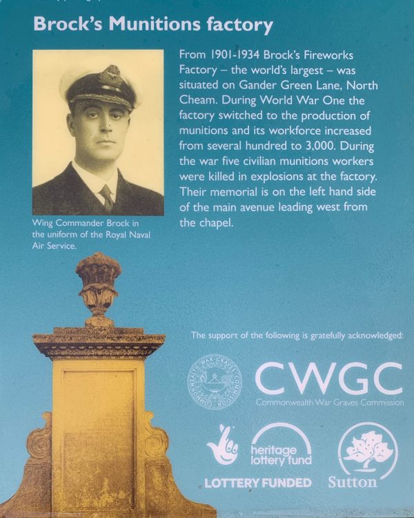 Notice explaining the memorial: "Brock's (sic) Munitions Factory. From 1901 to 1934 Brock's (sic) Firework Factory - the world's largest - was situated on Gander Green Lane, North Cheam. During World War One the factory switched to the production of munitions and its workforce increased from severl hundred to 3,000. During the war five civilian munitions workers were killed in explosions in the factory. Their memorial in on the left hand side of the main avenue leading west from the chapel." There is a photograph of Wing Commander Brock in uniform. The sign was placed by Surrey County Council. 