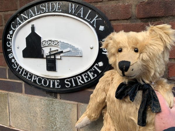 Close-up of Bertie and the "Canalside Walk Sheepcote Street" sign.