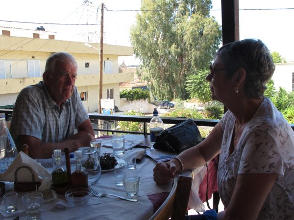 Bobby and Diddley enjoying a meal in a restaurant overlooking a village in Crete.