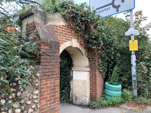 Ornate ivy-covered brick archway.