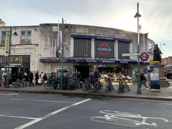 Exterior of Tooting Broadway Station. Slightly rundown looking, with a large number of bikes outside.
