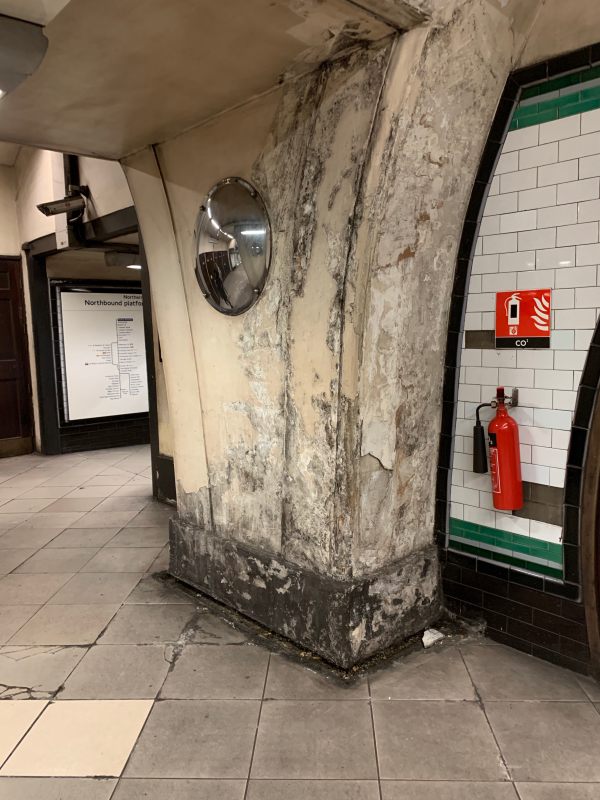 Pillar within Tooting Broadway station showing signs of damp in the plaster.