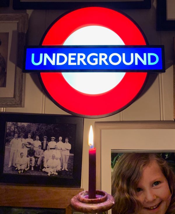 Lighting a Candle to Diddley. Underground illuminated roundel, family pictures and a lit candle.