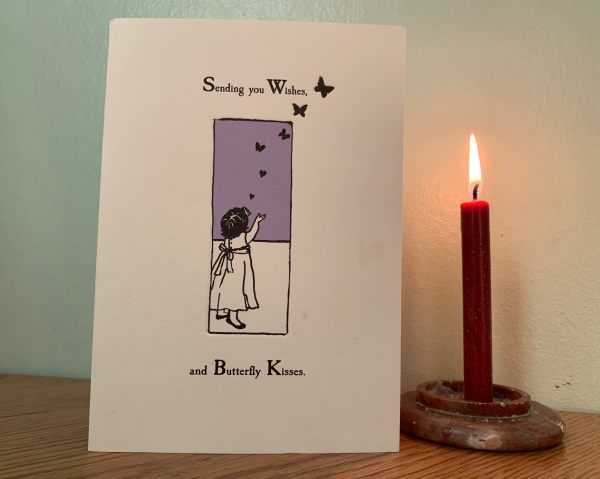 Lighting a Candle for Diddley. A card with "Sending you Wishes and Butterfly Kisses" written on it, alongside a lit candle.
