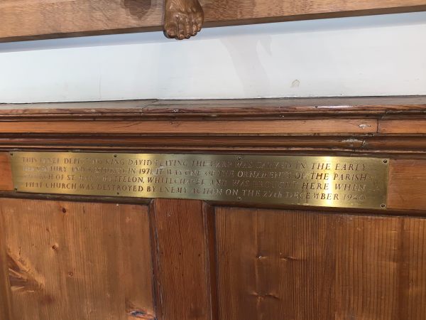 The brass plaque underneath the carving.