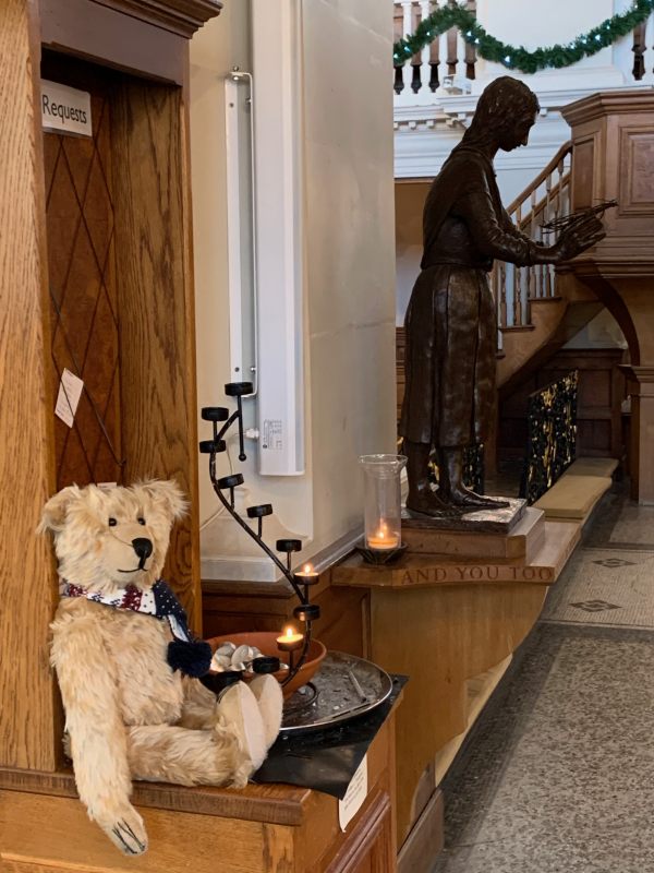 Bertie in front of a candle lit for Diddley, with the Mary of Sorrows behind.