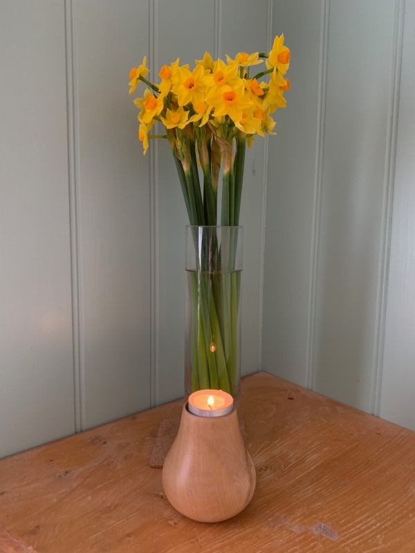 A lit candle for Diddly with some cut Soleil D’Or narcissus in a vase behind.