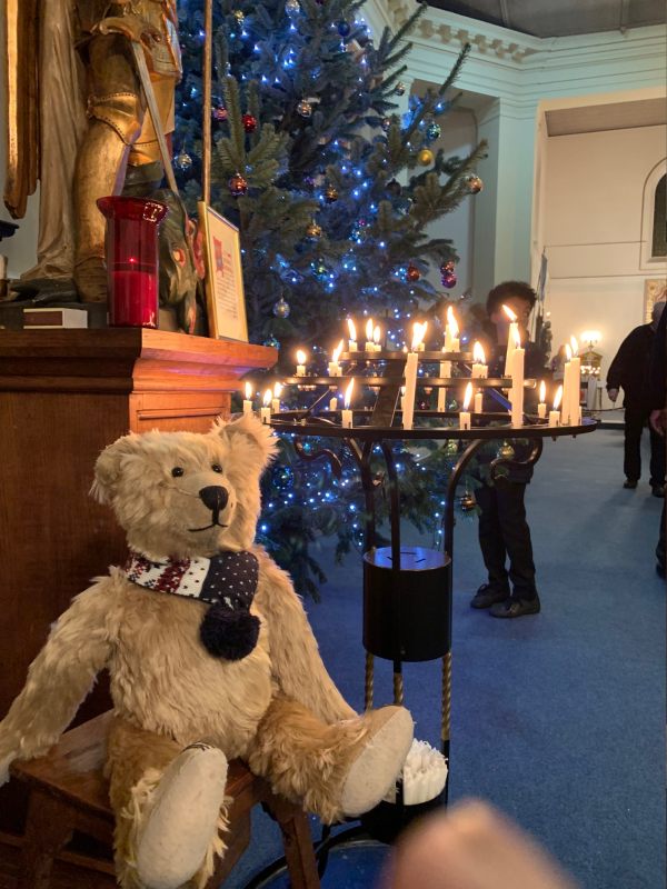 Bertie sat in front of a metal stand with several candles lit in remembrance.