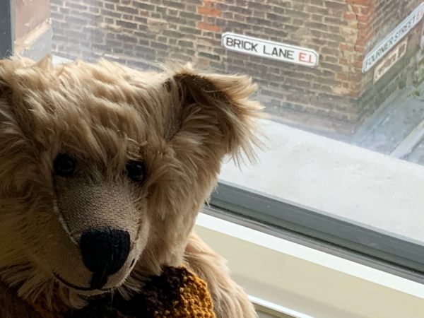 Bertie in the window of Room 311 with the street name "Brick Lane E1" visible outside.