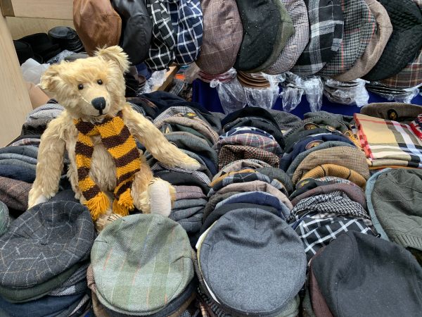 Bertie, wearing his Sutton United scarf, sat amongst the flat caps on the vintage hat stall in Spitalfields Market.