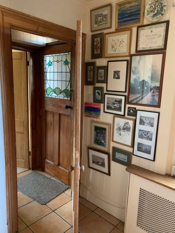 Looking through the open lounge door to the hallway and the closed front door.