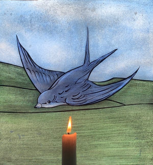 A candle lit for Diddley in front of the Bluebird window of Laurel Cottage.