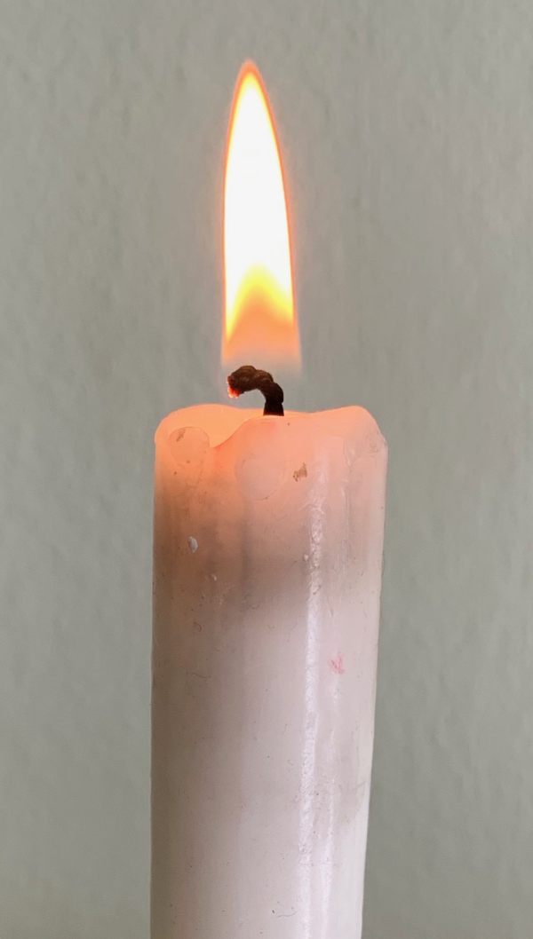 Close up of the flame of a candle lit for Diddley.