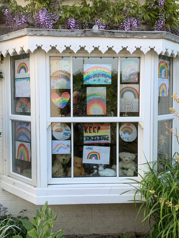 A bow window in Laurel Cottage with loads of messages and rainbows for the NHS.
