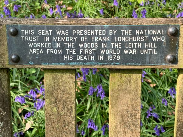 Plaque on the seat that reads "This seat was presented by the National Trust in moemory of Frank Longhurst who worked in the woods in the Leith Hill area from the First World War until his death in 1979".