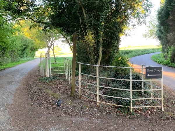 Sign pointing off the narrow country lane to "Trout Grange". A private estate with a Public footpath.