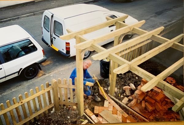 Bobby, in his boiler suit, building the Victorian style pathway under the new pergola. His "little white van" parked on the road behind him.