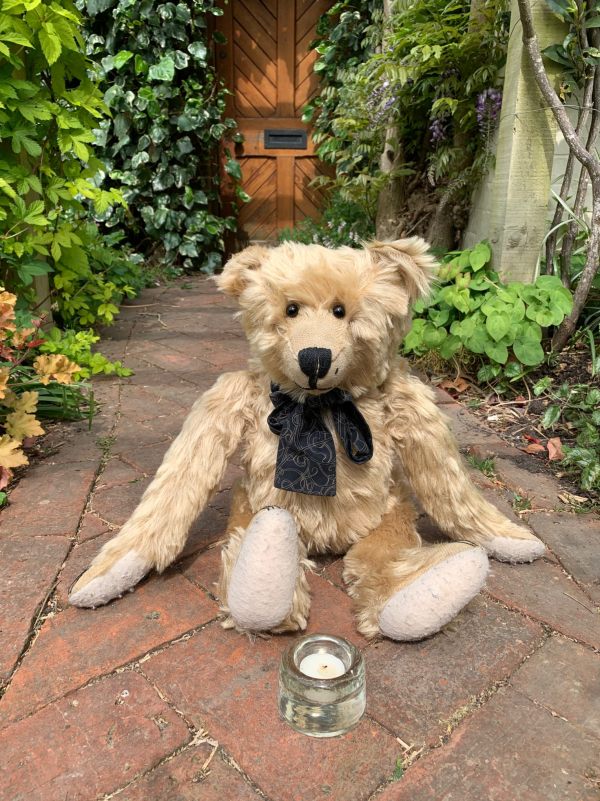 Bertie sat on the herringbone path with a lit candle for Diddley in front of him.