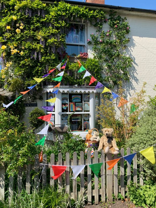 Laurel Cottage. The bunting is not red, white and blue but instead rainbow coloured and suits the window.